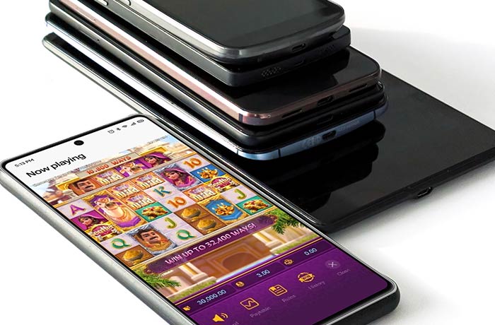 A stack of mobile phones with one showing an iGaming slot game, all ready for crowdsourced testing on different devices